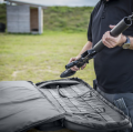 pokrowiec Double Upper Rifle Bag Shadow Grey ułożony na stole ze sprzętem strzeleckim