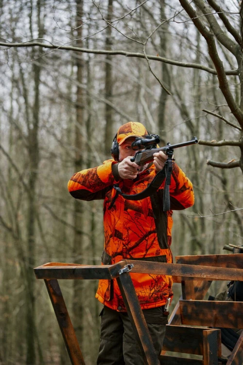 myśliwy w kurtce Deerhunter Eagle 5785 pomarańczowej w lesie